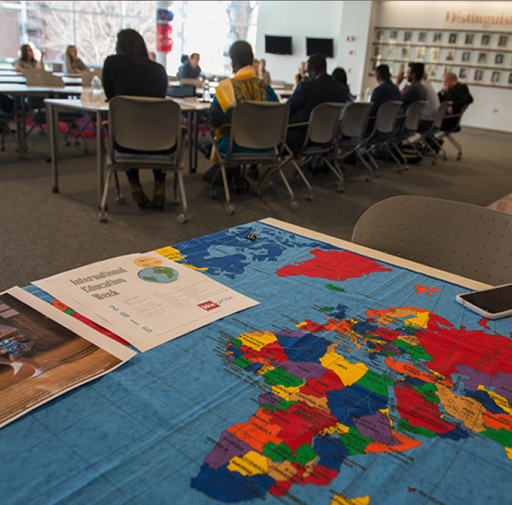 World map on table with students in background