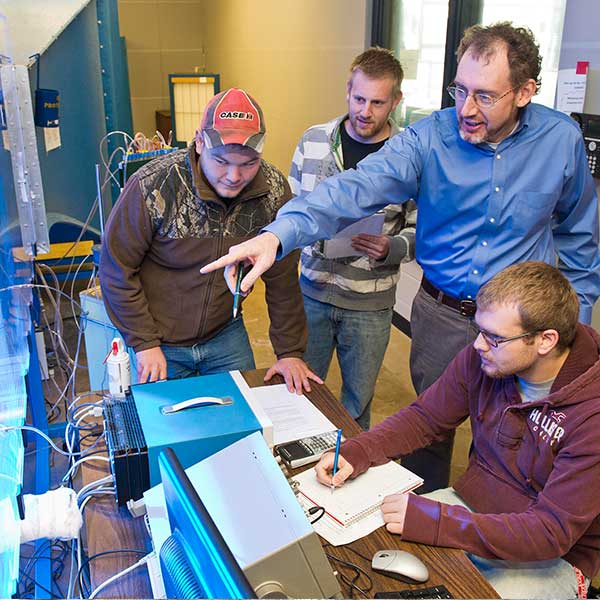 Students and professor looking at data on a computer.