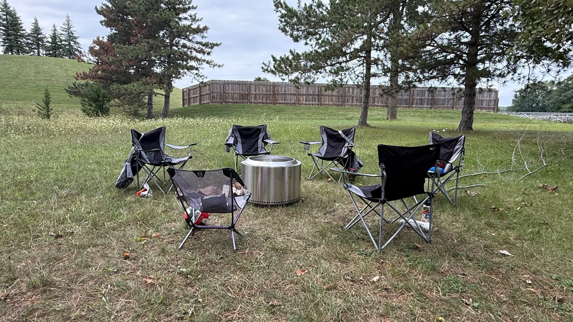 Camping chairs arranged around a fire pit on campus