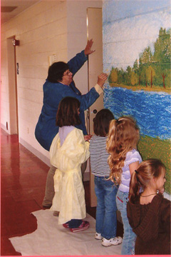 Kids coloring a mural on the wall