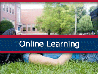 An adolescent student lays on the grass while working on a laptop. A ribbon that says 