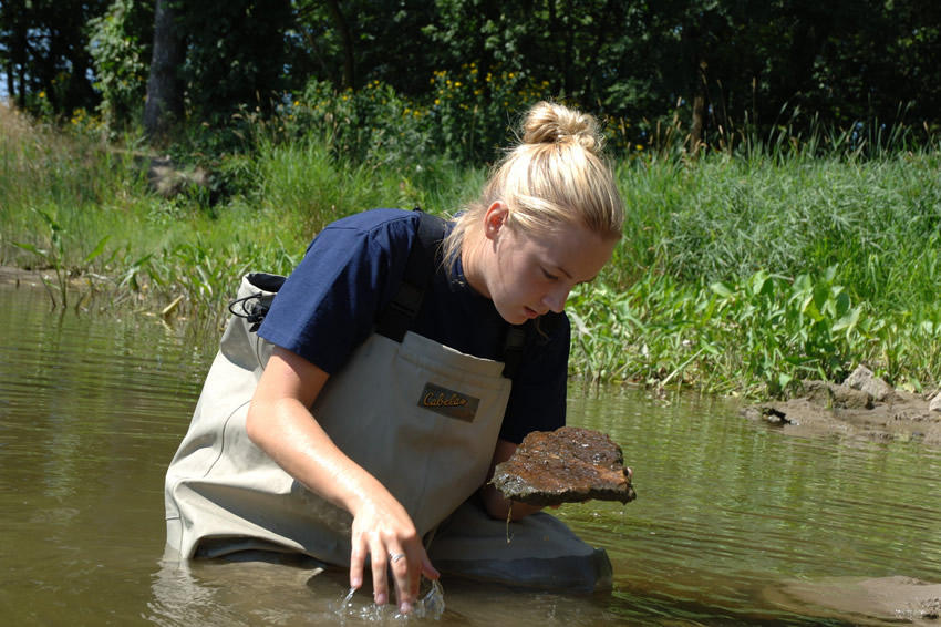 Student taking samples in river