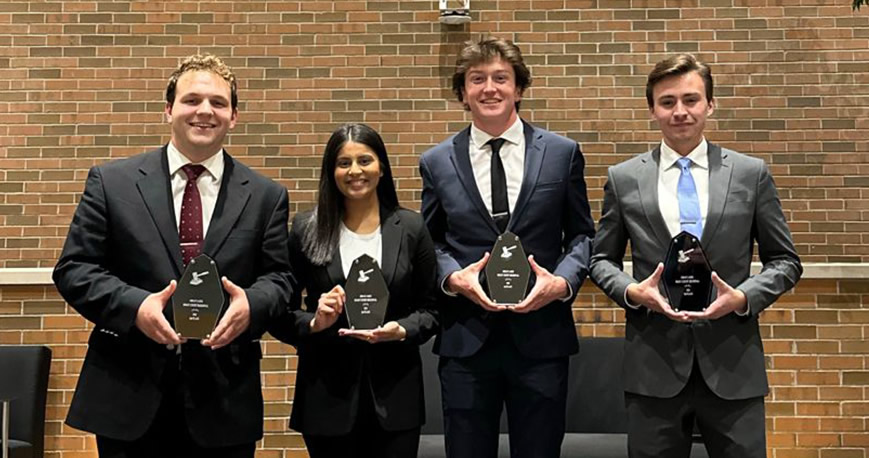 Four Moot Court team members pose for photo with awards