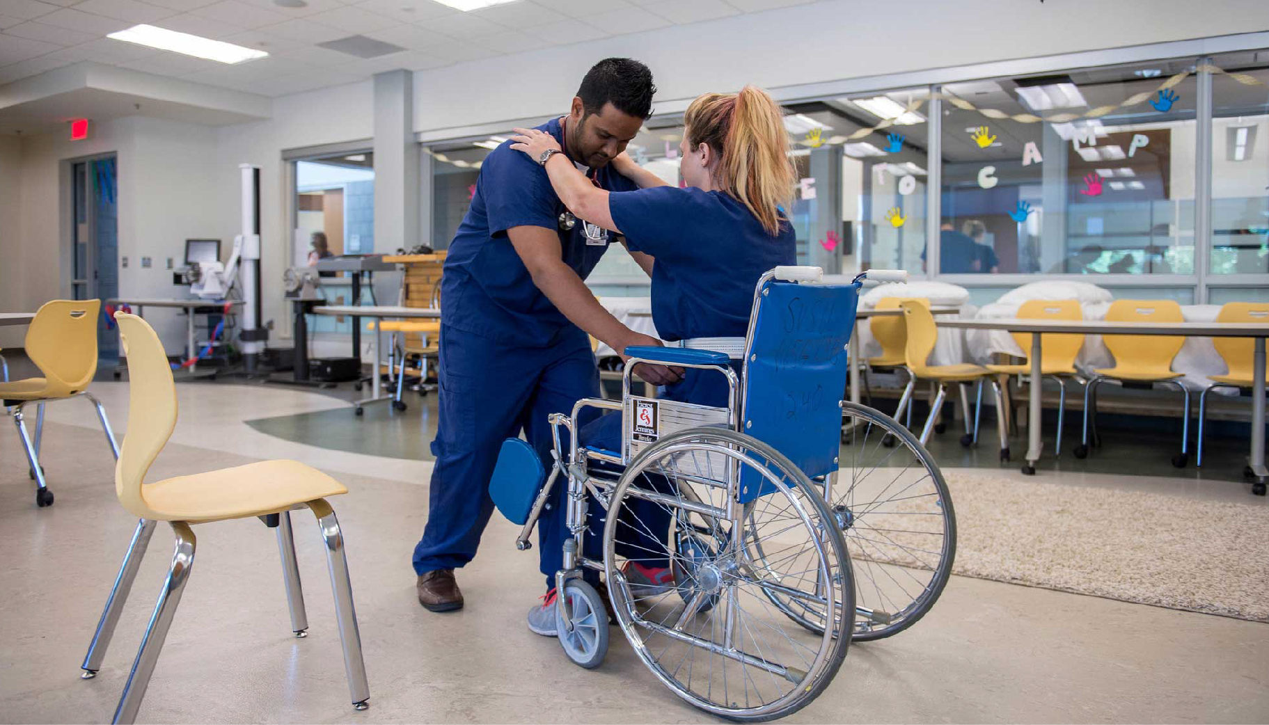 A nursing student demonstrating a wheelchair