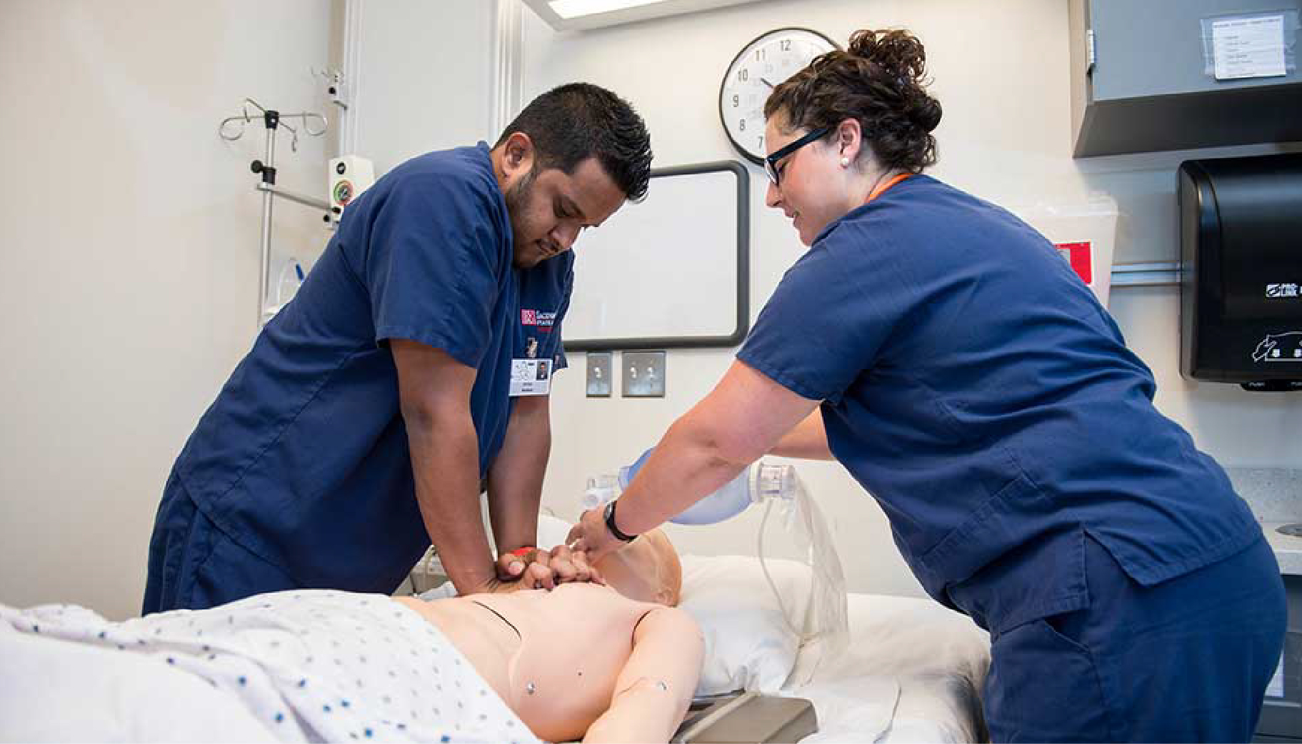 Two nursing students performing CPR on a test dummy