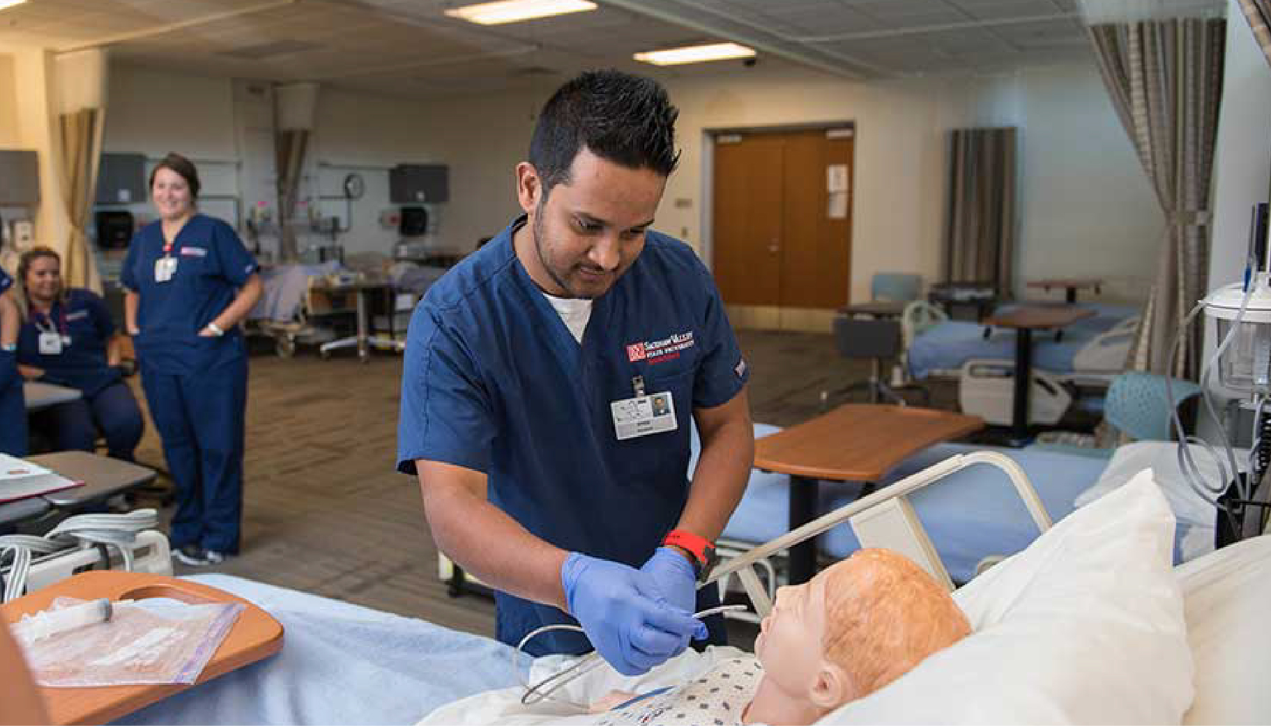 A nursing students looking at a test dummy
