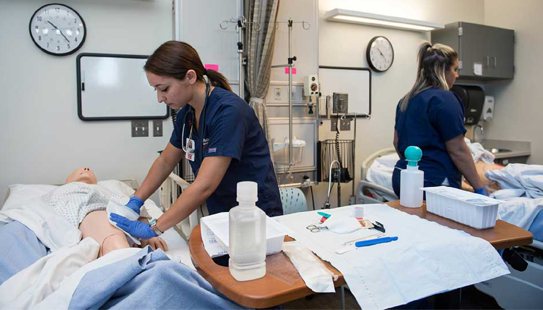 A nursing student caring for a test dummy