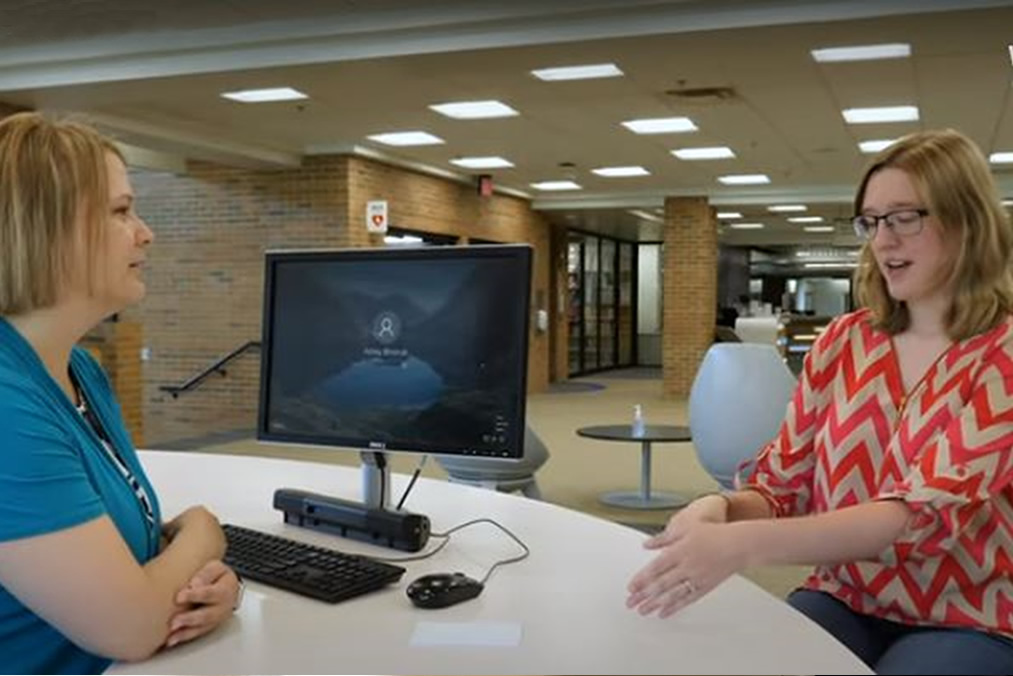 Library employee providing assistance to student
