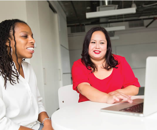 MPA graduate working in office with another person