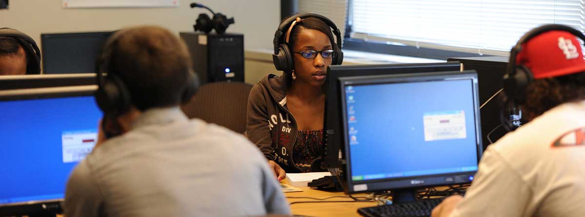 Computer assisted language learning lab for the Department of Modern Foreign Languages. Brown Hall 203. Students with headphones at computer stations. 