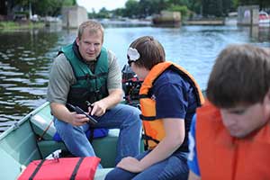 Dr. David Karpovich leads a group of students researching water quality on the Kawkawlin River.