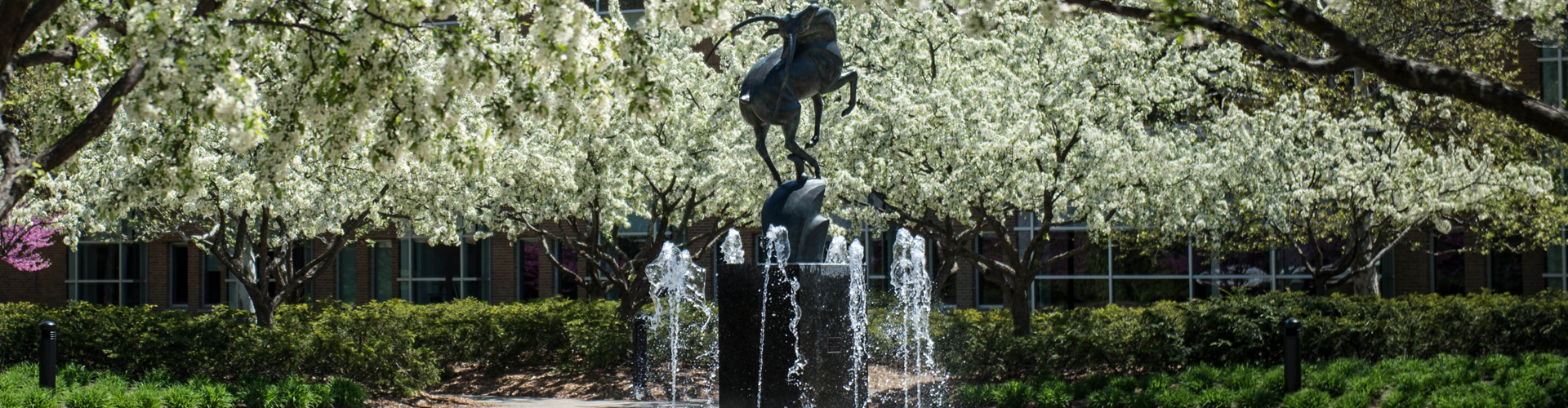 Image of the Leaping Gazelle fountain in the spring with flowering trees