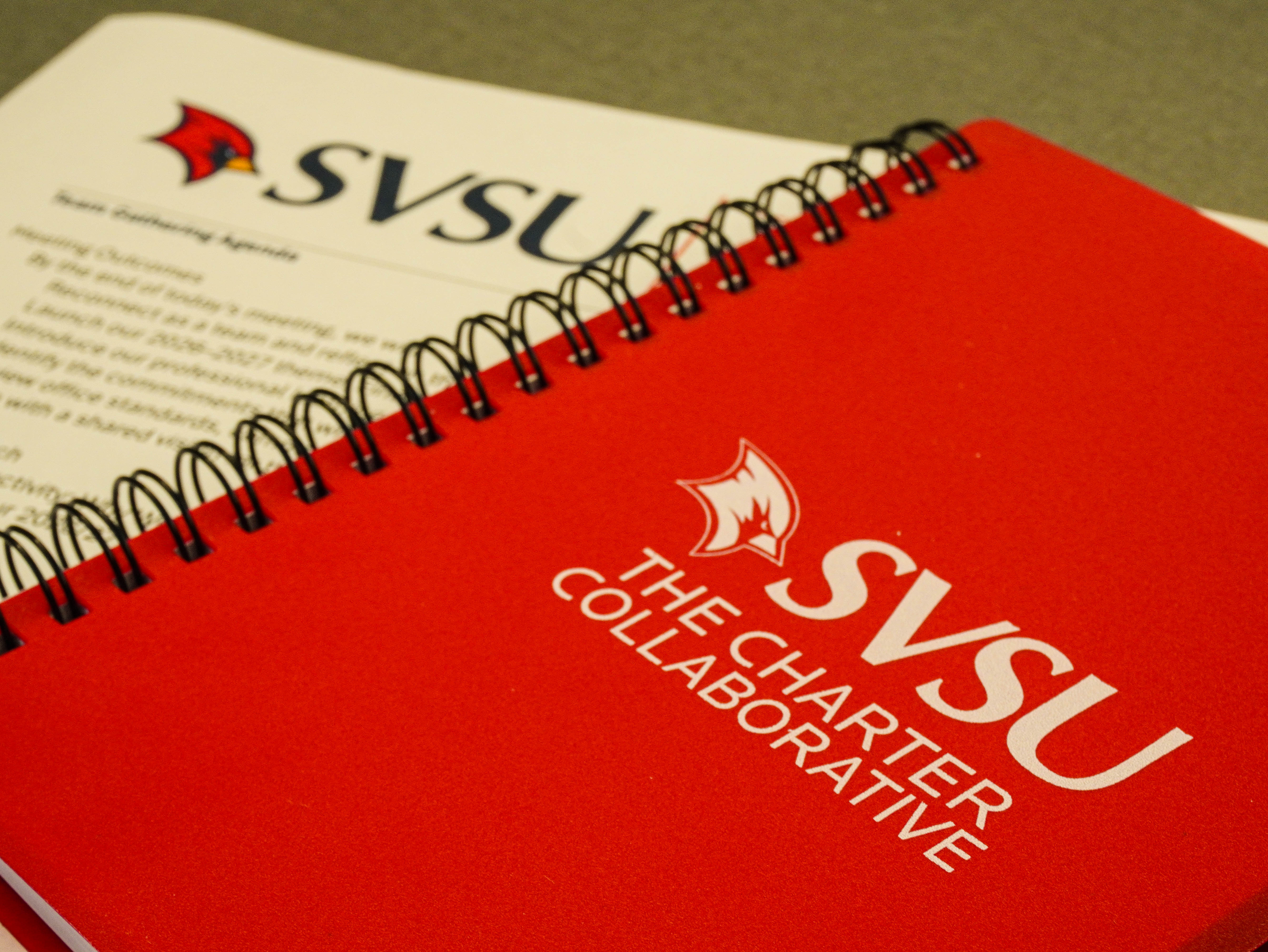 A notebook of the charter Colaborative logo on it.