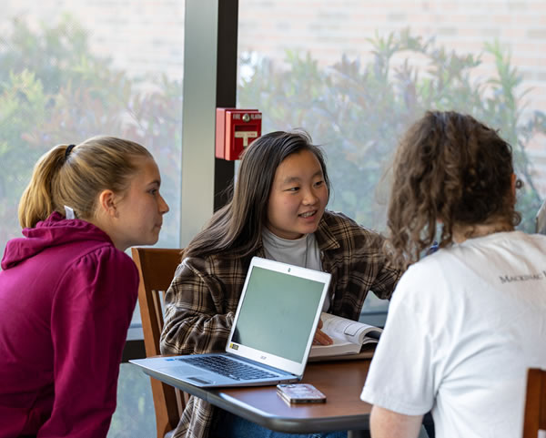 Students at a table with a laptop