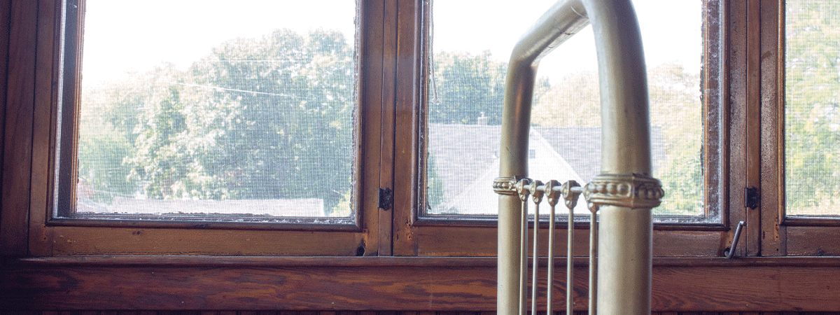 A metal bedframe in front of windows